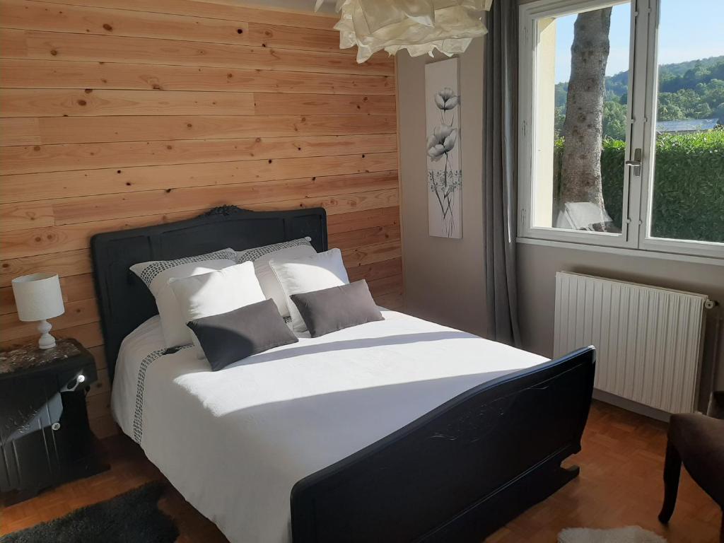 a bedroom with a large bed with a wooden wall at Chambre Candésie in Pouzac