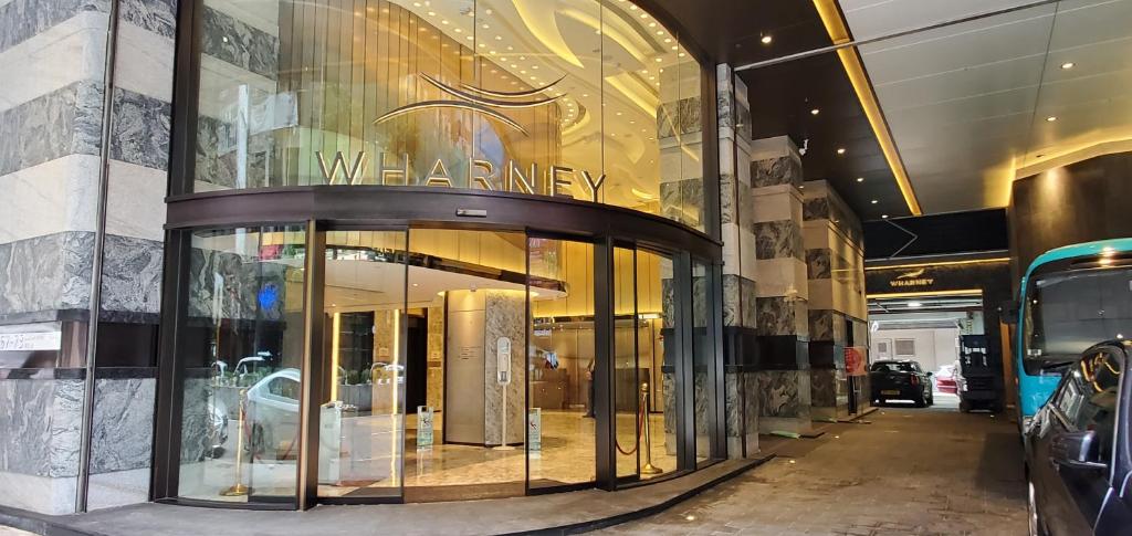 een winkel voor een gebouw met glazen ramen bij Wharney Hotel in Hong Kong