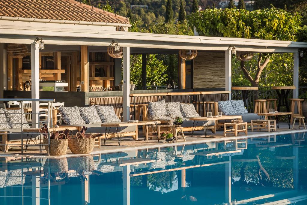a swimming pool with lounge chairs and a house at Avithos Resort Hotel in Svoronata
