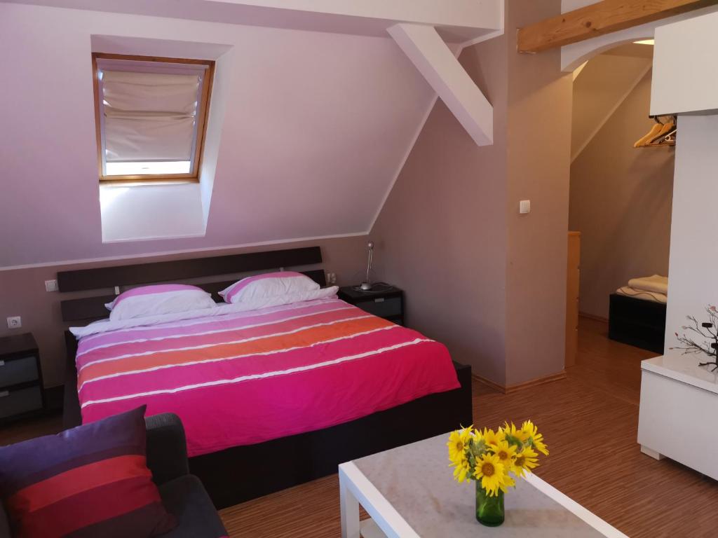 sypialnia z różowym łóżkiem i kanapą w obiekcie Vetrovi šumijo II w mieście Kapele