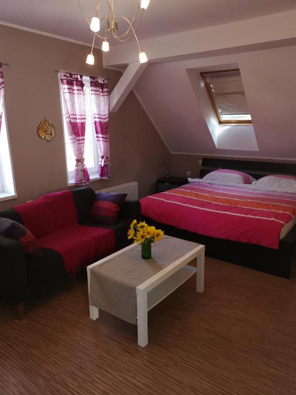 a bedroom with a bed and a couch and a table at Vetrovi šumijo II in Kapele