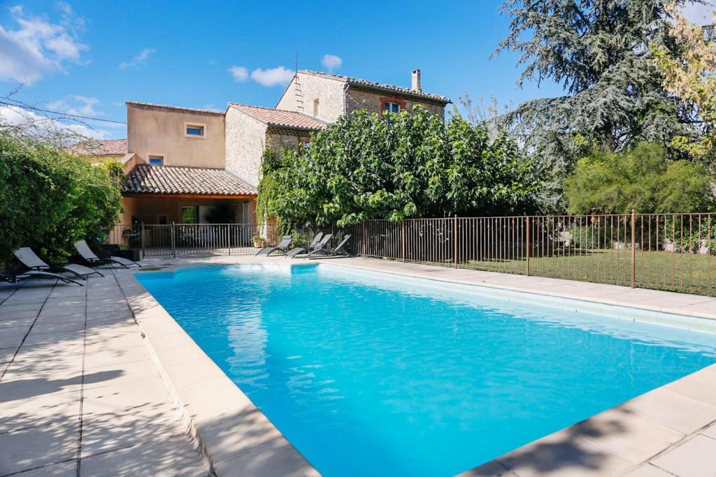 una piscina di fronte a una casa di Villa de 4 chambres avec piscine privee jardin clos et wifi a Caromb a Caromb