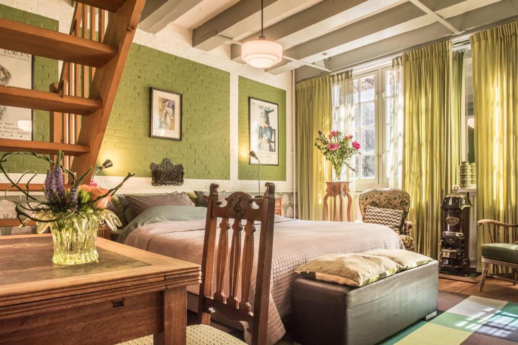 ein Schlafzimmer mit einem Bett und einem Tisch in einem Zimmer in der Unterkunft Studio Koggeschip in Amsterdam
