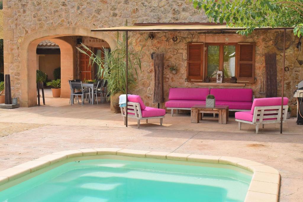 una piscina con muebles de color rosa y un patio en Finca Son Fonto 097 by Mallorca Charme, en Manacor