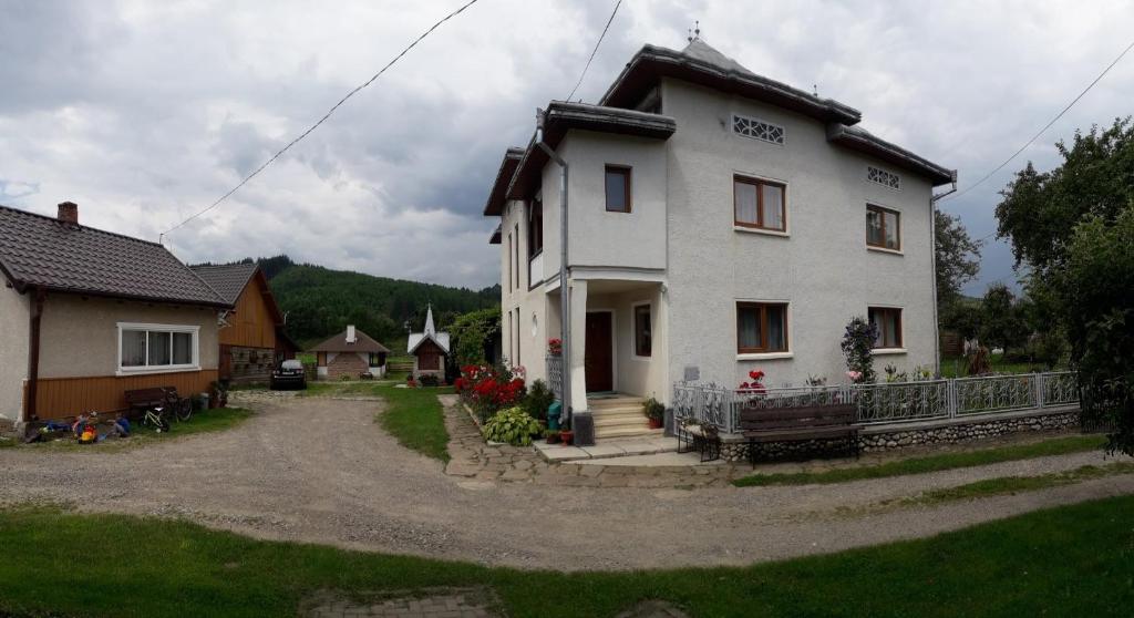 une maison blanche avec une allée devant dans l'établissement Casa Sandina, à Vama