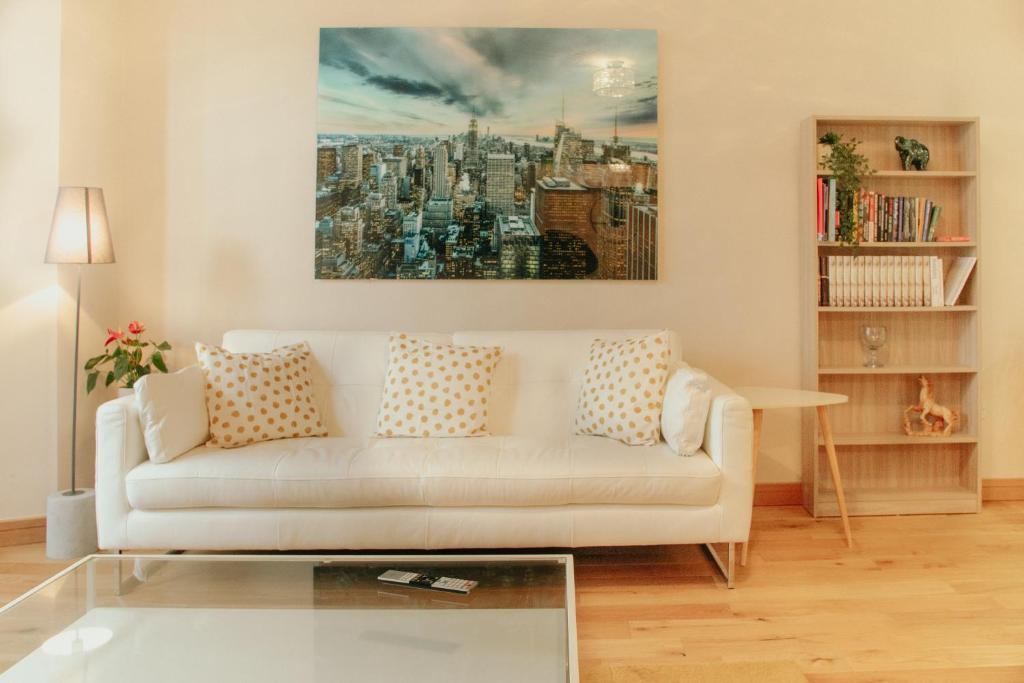 Bessemer House Apartments في Attercliffe: غرفة معيشة بها أريكة بيضاء و لوحة