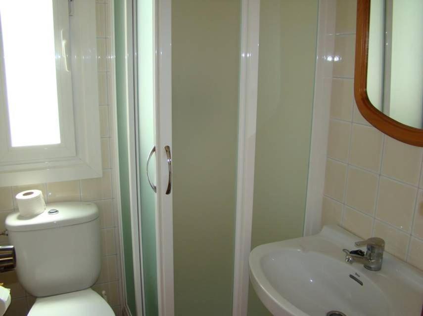 a bathroom with a shower and a toilet and a sink at Villa Norde - A Family-friendly villa with pool and 3 bedrooms in Son Bou