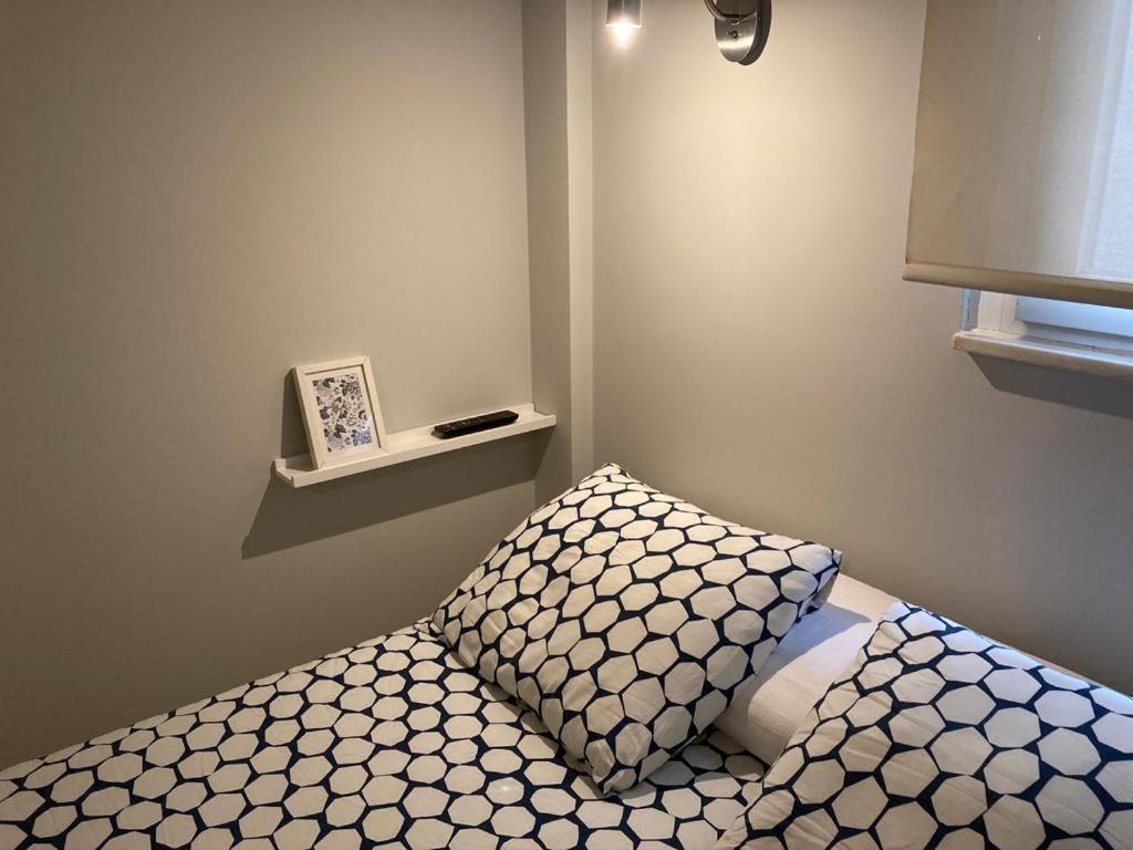 a bedroom with a bed with a pillow and a shelf at New Studio Sito 6 Parking Gratis in Salamanca