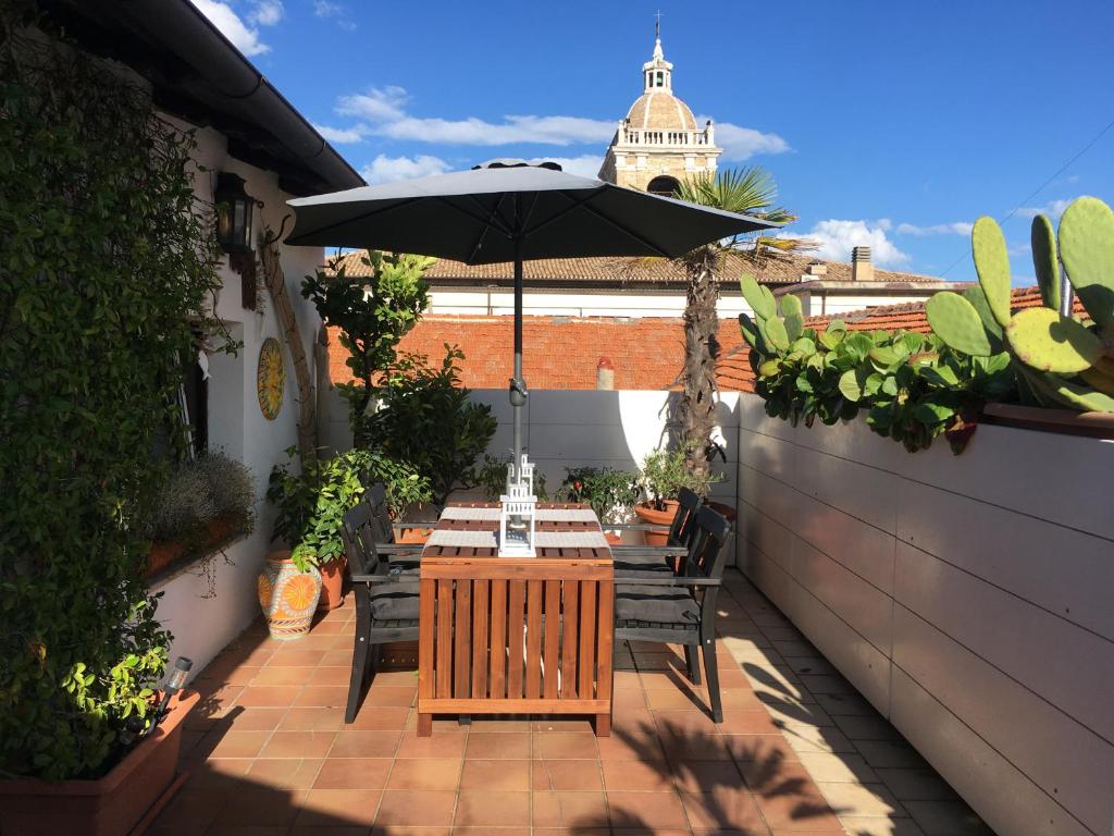 einen Tisch und Stühle mit Sonnenschirm auf einer Terrasse in der Unterkunft La Terrazza Sui Tetti in Senigallia