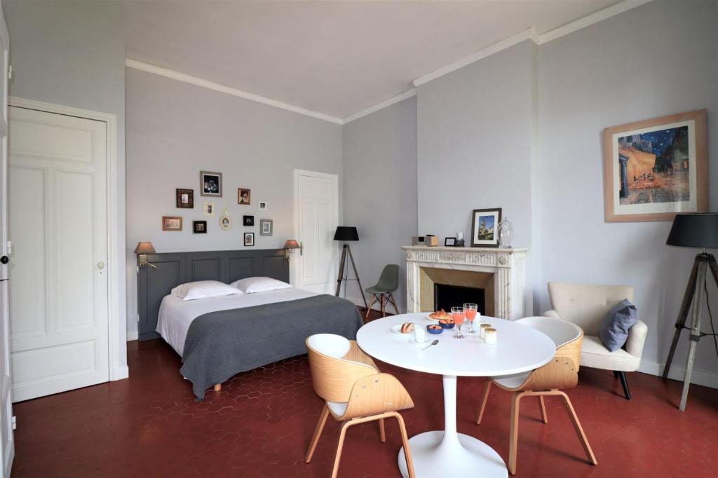 a room with a bed, chair, table and a lamp at Maison Dormoy in Marseille
