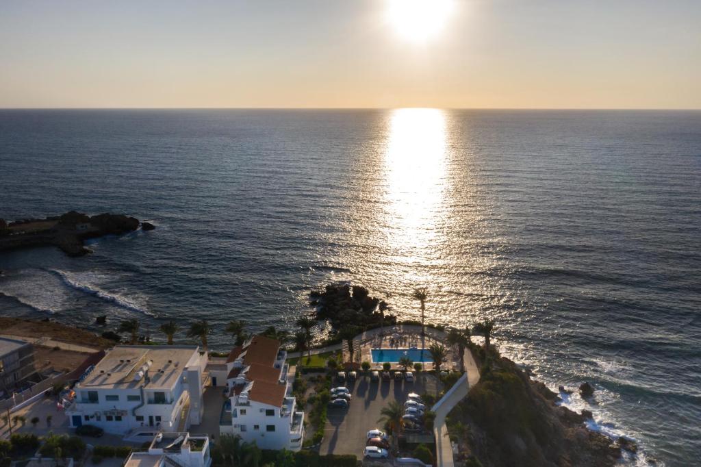 an aerial view of the ocean at sunset at Vrachia Beach Hotel & Suites - Adults Only in Paphos