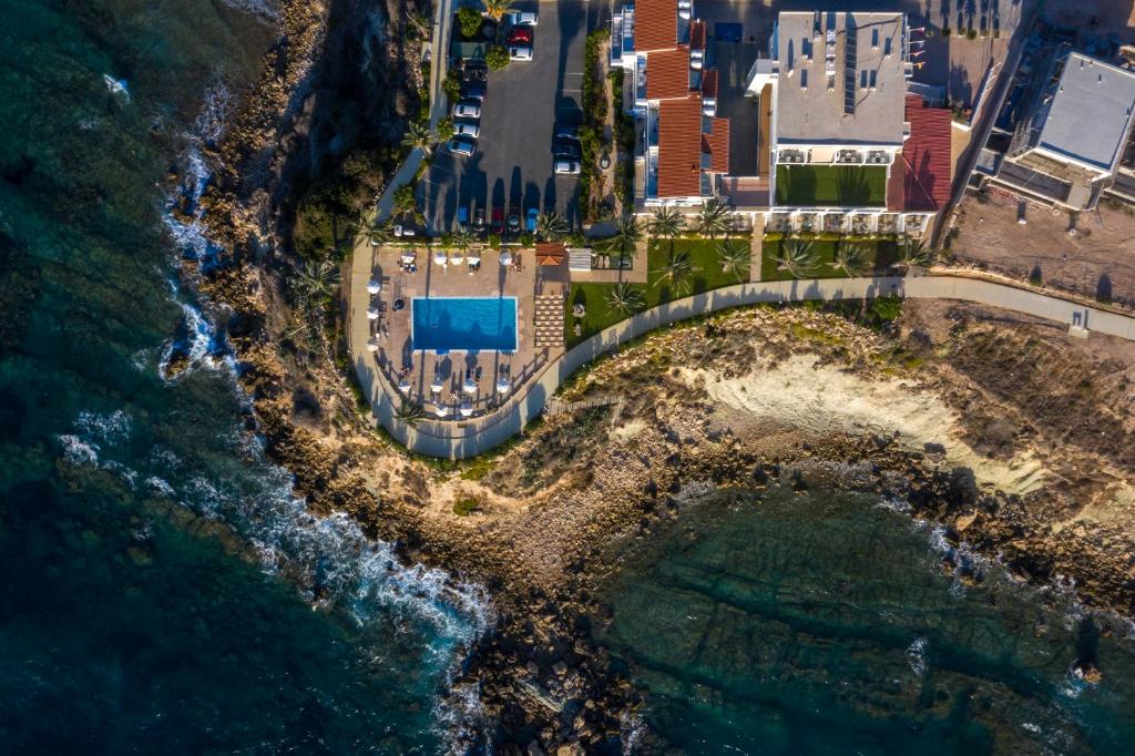 an aerial view of an island in the ocean at Vrachia Beach Hotel & Suites - Adults Only in Paphos City