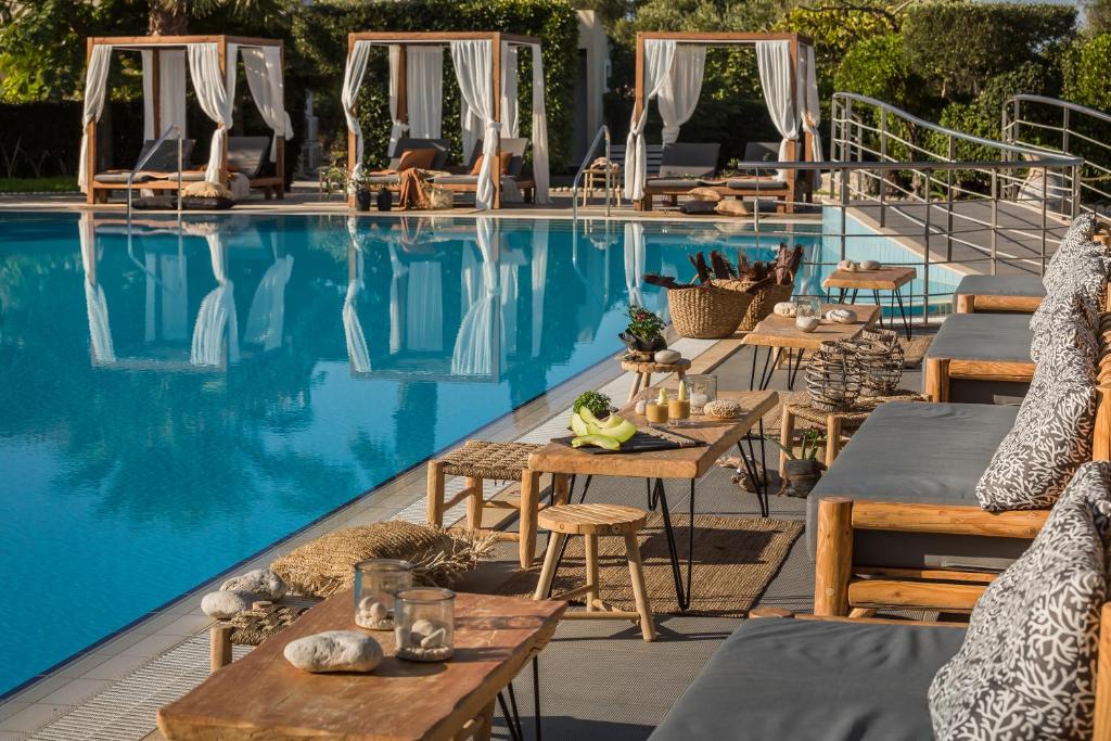 a pool with tables and chairs next to a hotel at Avithos Resort Hotel in Svoronata