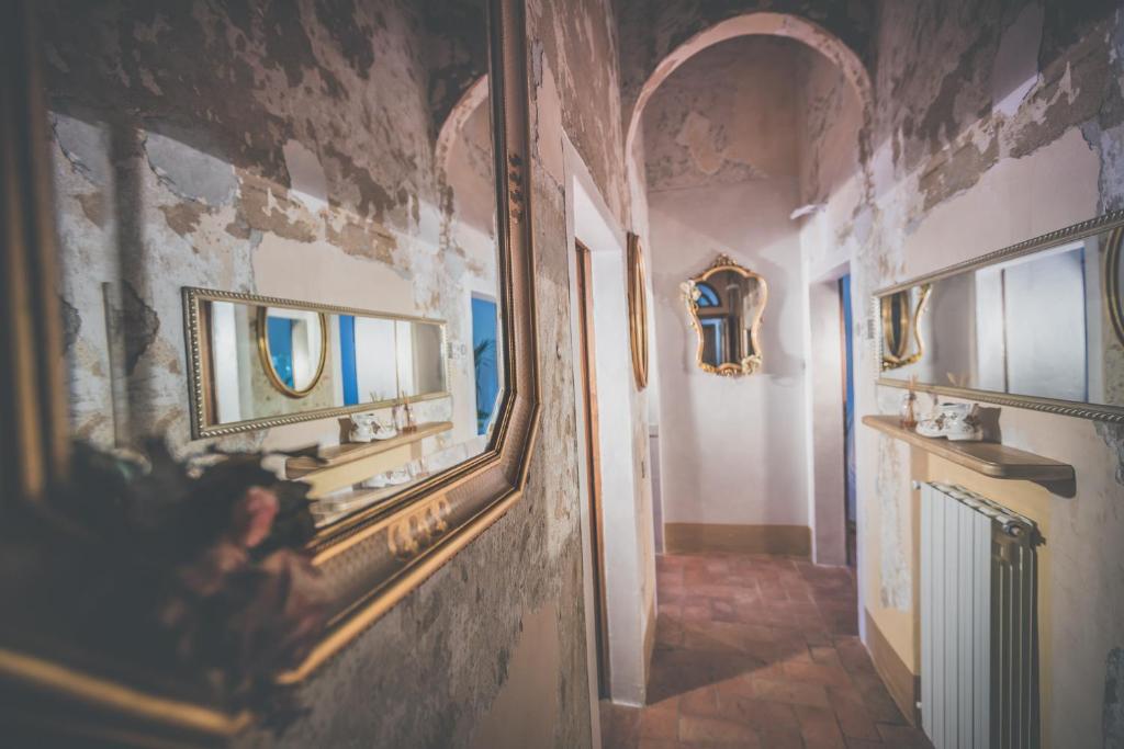 un couloir avec un miroir mural dans l'établissement Villa d'Orcia - Homelike Villas, à Castiglione dʼOrcia 15 autres photos
