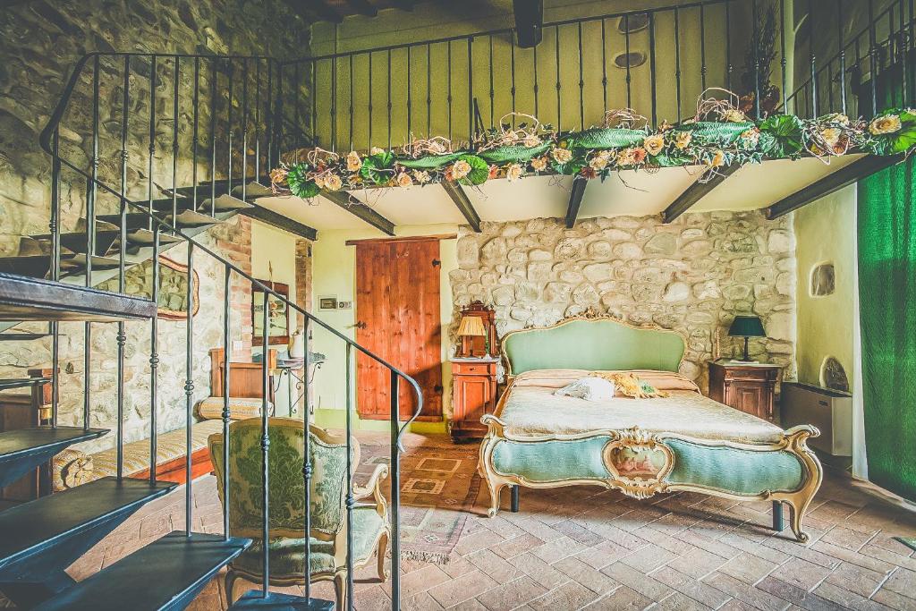une chambre avec un lit dans un mur de pierre dans l'établissement Villa d'Orcia - Homelike Villas, à Castiglione dʼOrcia