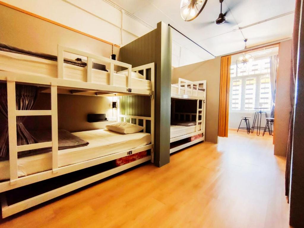 two bunk beds in a room with wooden floors at Hub Hostel Hatyai in Hat Yai