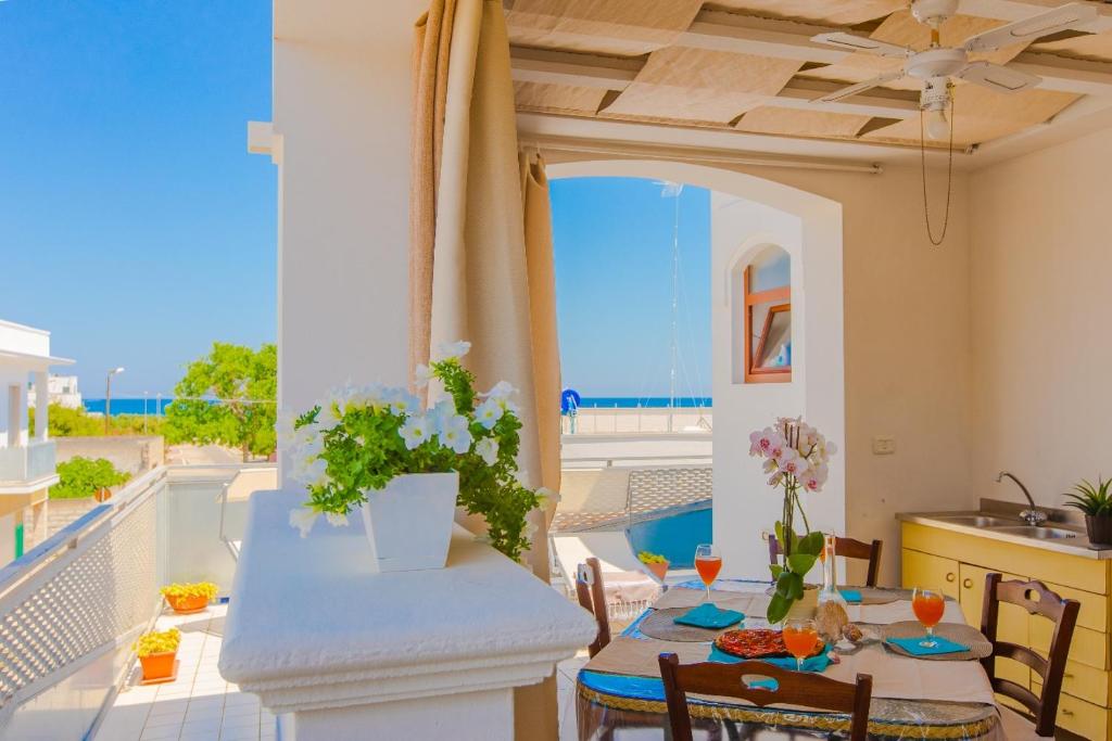 a dining room with a table and a view of the ocean at Appartamento Pineta Mare in Specchiolla