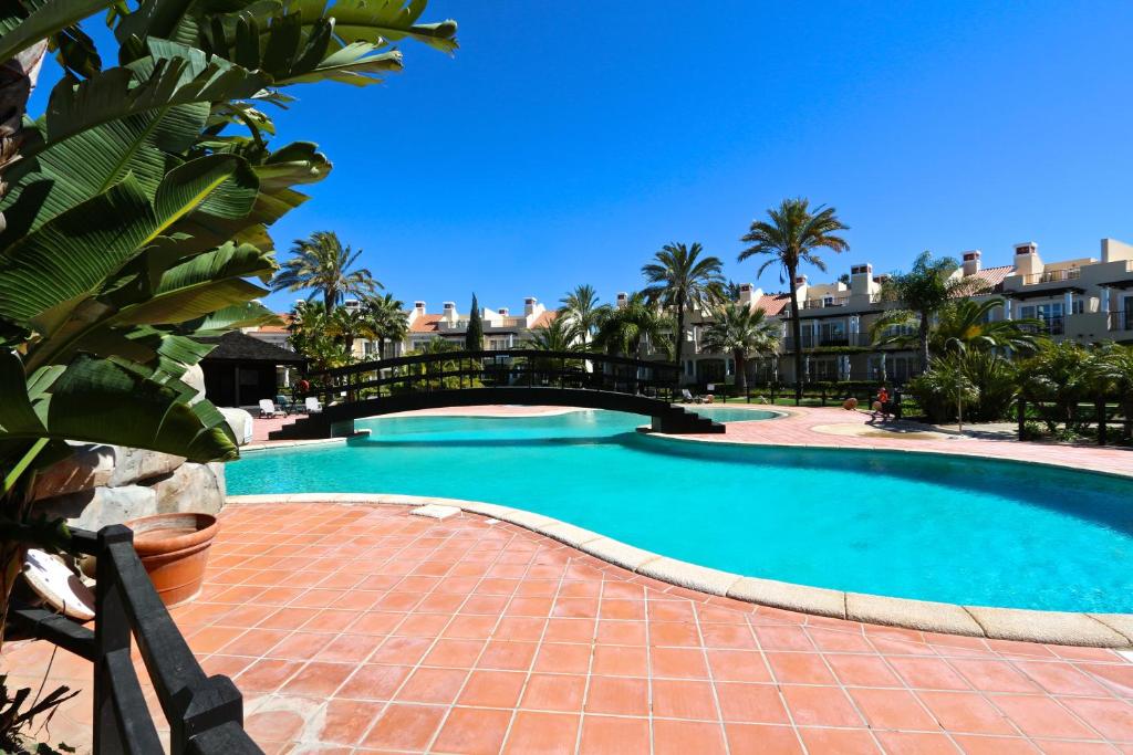 een groot zwembad met een bakstenen loopbrug en palmbomen bij Villa Casa da Luz, Palmyra 173 - Clever Details in Vilamoura