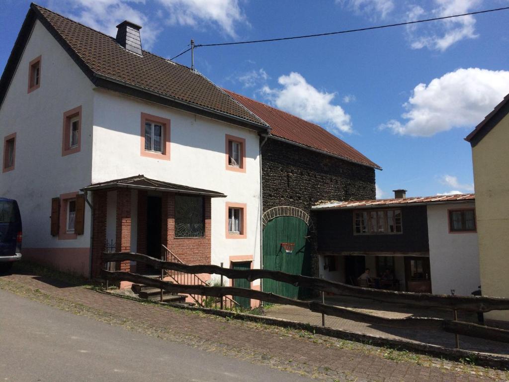 a white house with a green door on a street at Ferienhaus-Ilstad in Udler