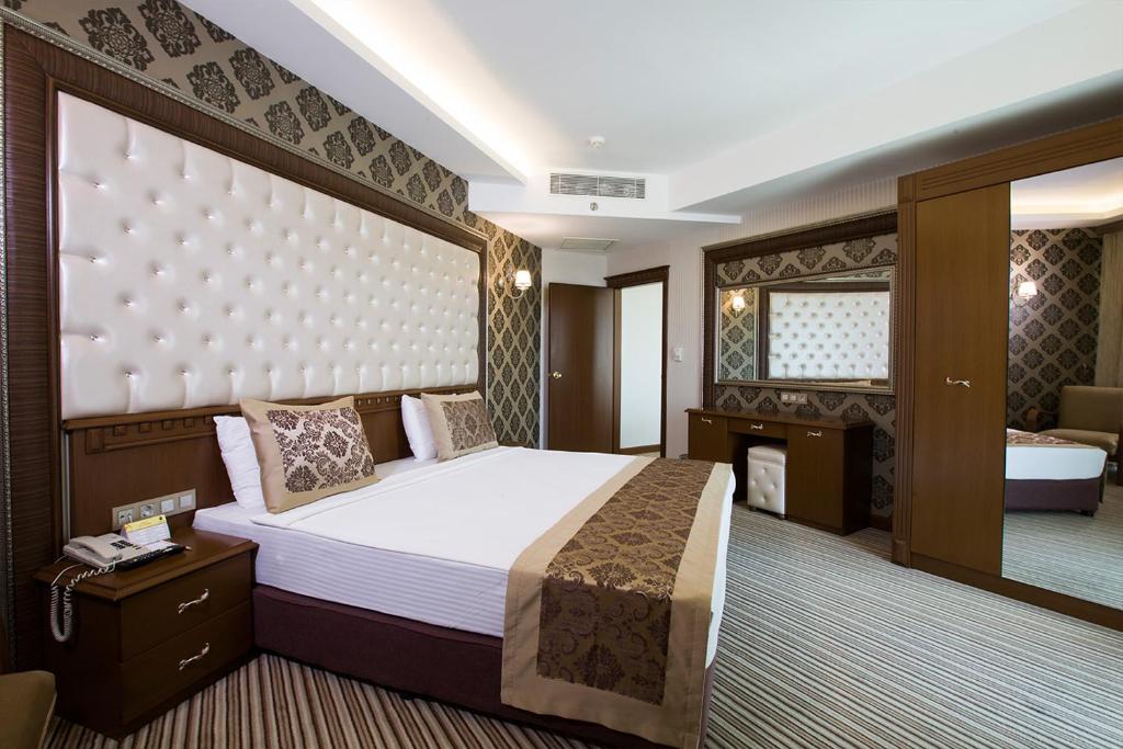 a bedroom with a large bed and a bathroom at Grand Altuntas Hotel in Aksaray