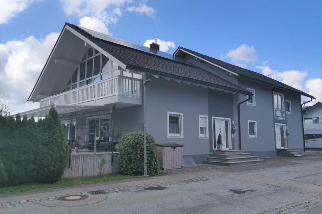 a gray house with a balcony on a street at Ferienwohnung Neuerer in Riedlhütte