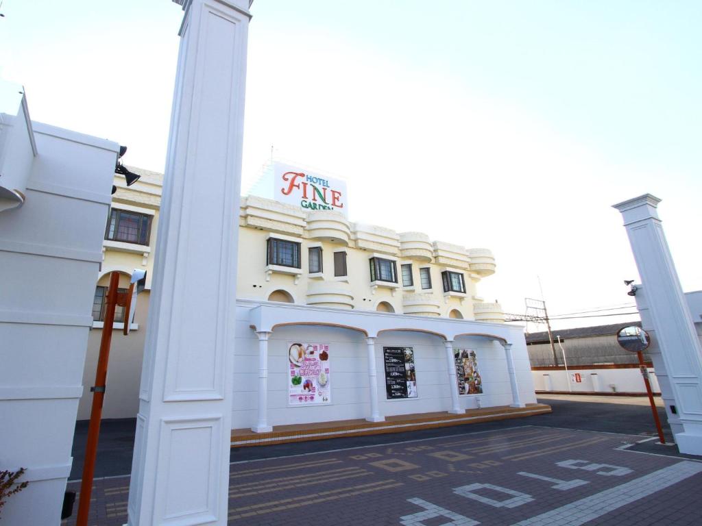 a white building with a sign on the side of it at Hotel Fine Garden Suzuka in Suzuka