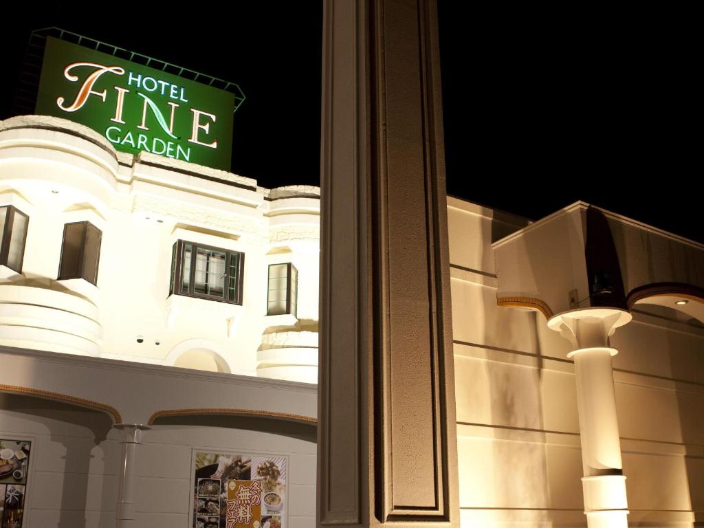 a white building with a sign on top of it at Hotel Fine Garden Suzuka in Suzuka