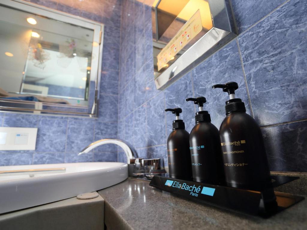 two black bottles sitting on a counter in a bathroom at Hotel Fine Garden Suzuka in Suzuka