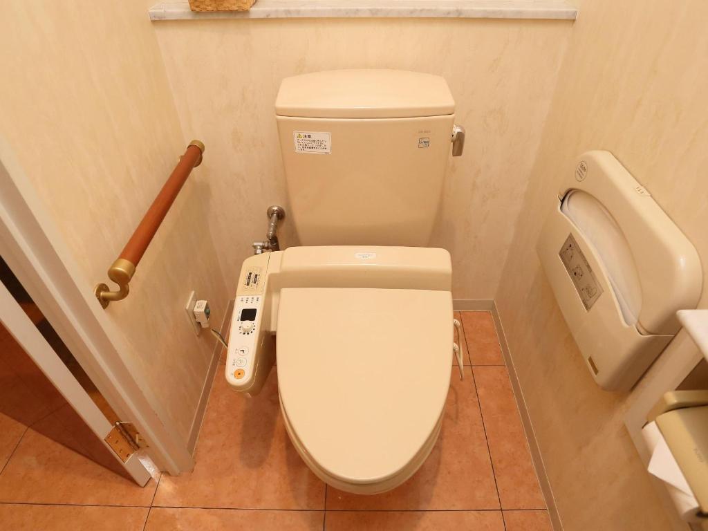 a bathroom with a toilet and a urinal at Hotel Fine Garden Suzuka in Suzuka