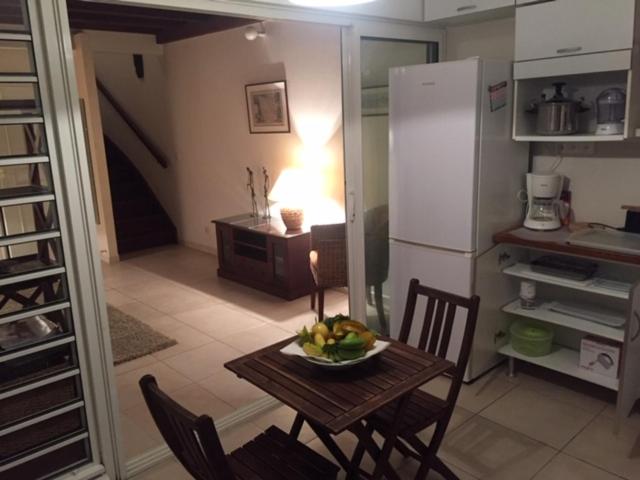 a kitchen with a table with a bowl of fruit on it at BAY VIEW MARTINIQUE in Les Anses-dʼArlets