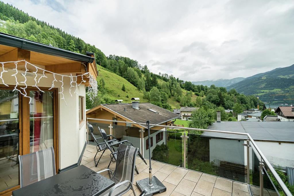 einen Balkon eines Hauses mit einem Tisch und Stühlen in der Unterkunft Chalet Schmittenbach - Pinzgau Holidays in Zell am See
