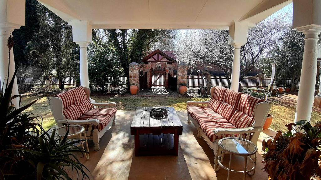 a patio with couches and a table and a gazebo at Bluebell Country House in Dullstroom