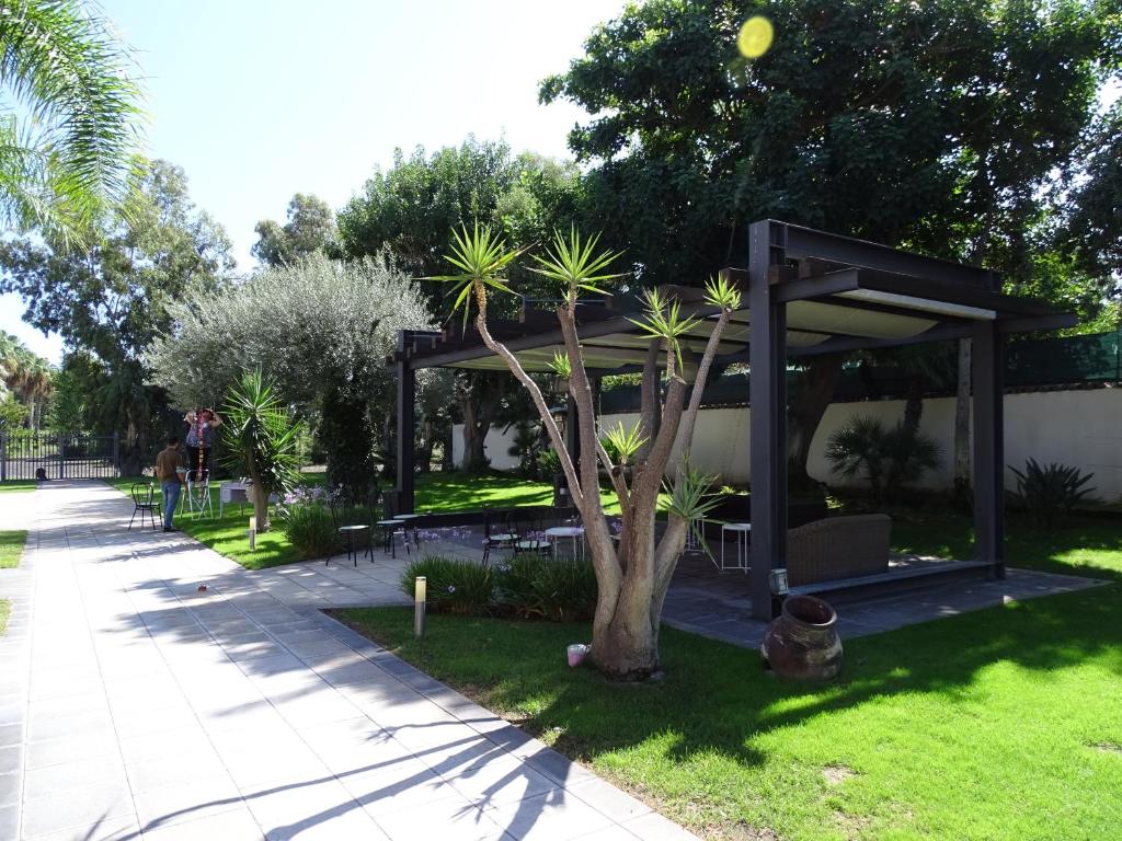 a pavilion with a tree in a park at La casetta al maneggio in Catania