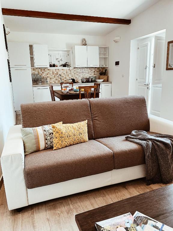 a living room with a couch and a kitchen at La casetta al maneggio in Catania