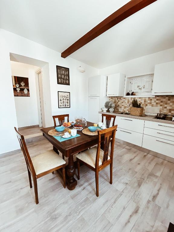 a kitchen with a wooden table and chairs at La casetta al maneggio in Catania