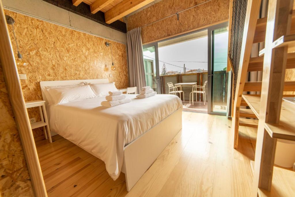 ein Schlafzimmer mit einem großen Bett und einem großen Fenster in der Unterkunft Albergaria da Tomásia in Aldeia do Meco