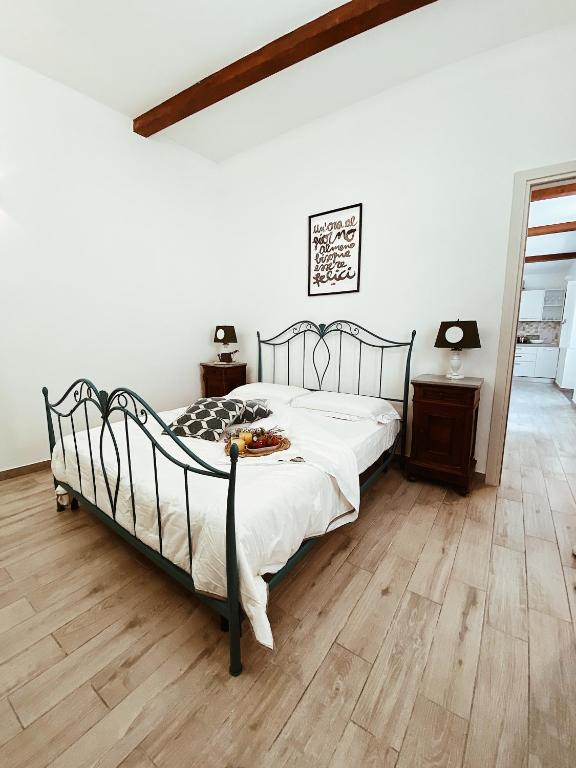 a bedroom with a bed and a wooden floor at La casetta al maneggio in Catania