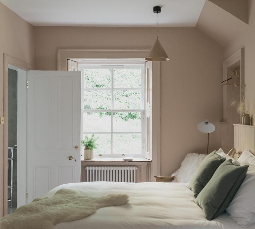 Un dormitorio con una gran cama blanca y una ventana en The Taybank, en Dunkeld