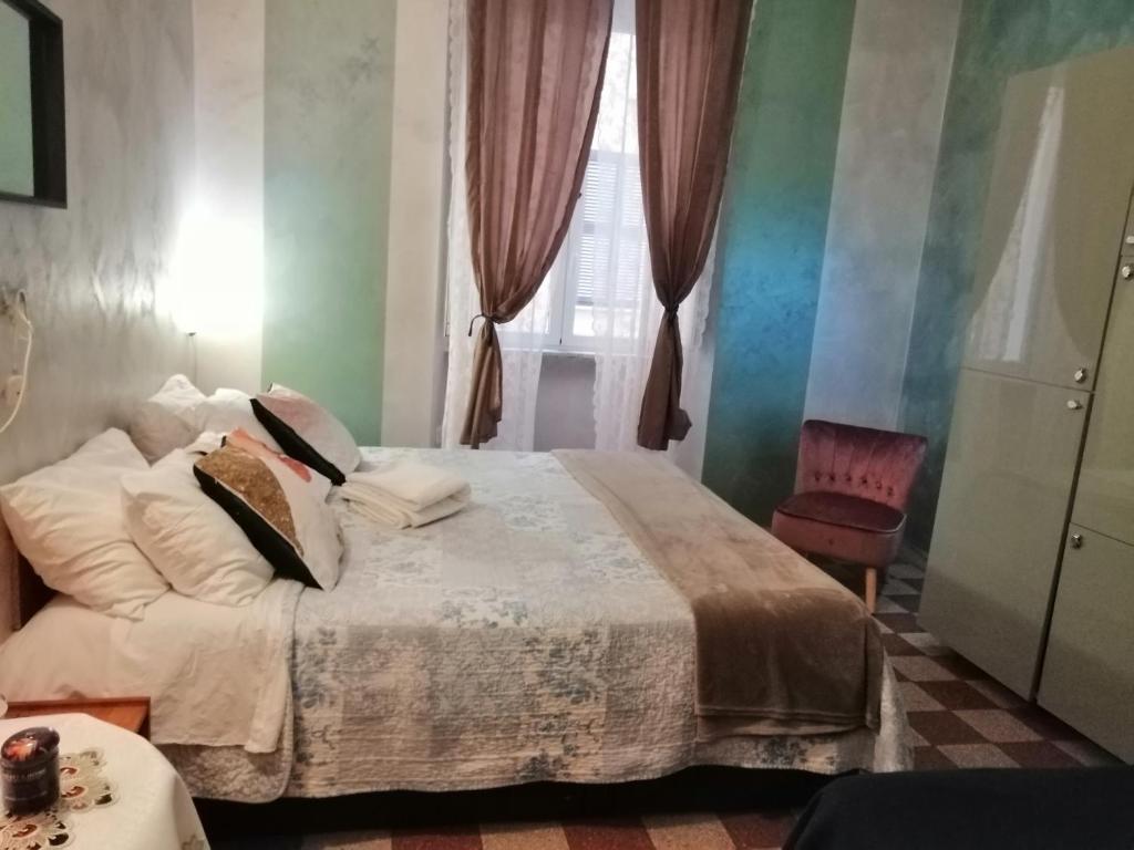 a hotel room with a bed, table, lamps and curtains at Român Holidays in Rome