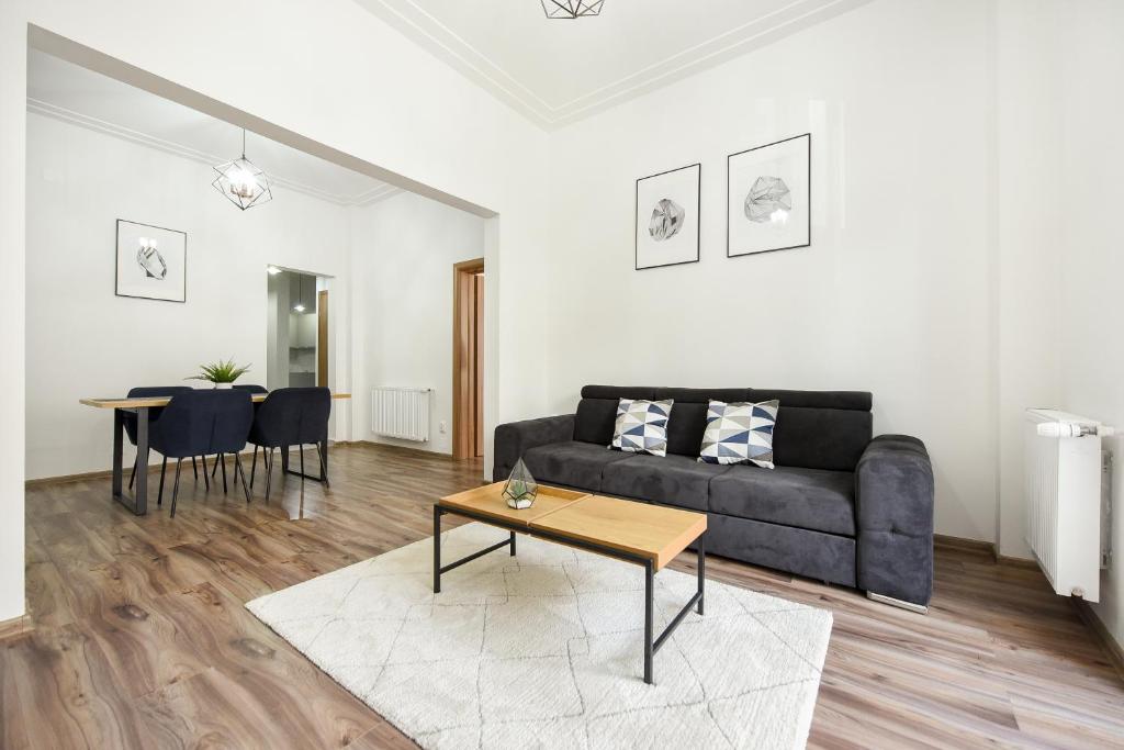 a living room with a couch and a table at SIMPLE YET STYLISH. Piata Revolutiei Apartment in Bucharest
