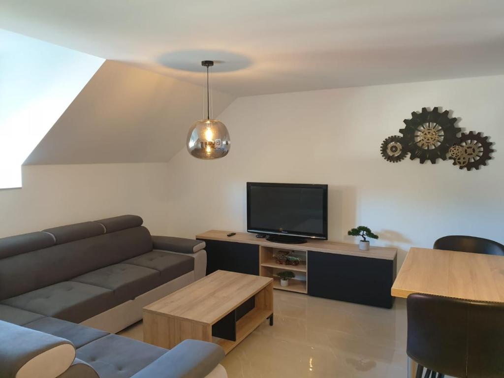 ein Wohnzimmer mit einem Sofa und einem Flachbild-TV in der Unterkunft Apartmani New York in Nova Gradiška