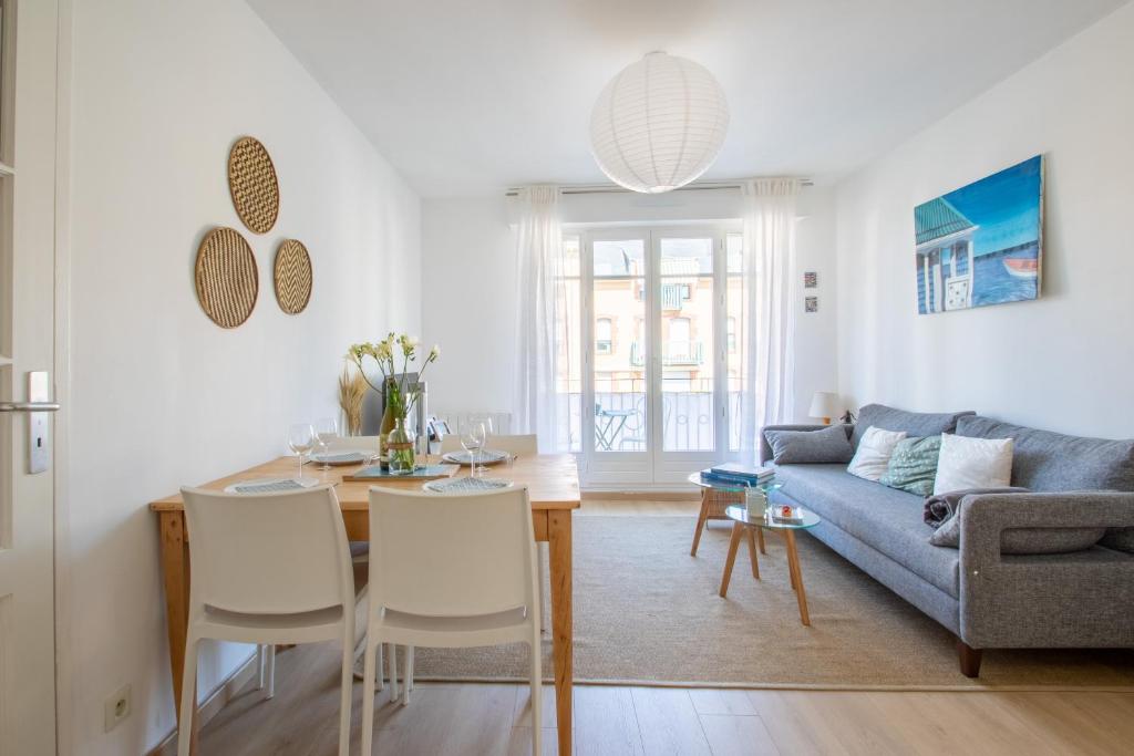 uma sala de estar com uma mesa e um sofá em Le Coton em Saint Malo