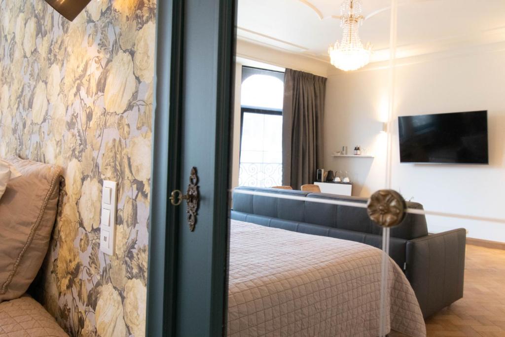 a bedroom with a bed and a living room at Porta Superia Boutique B&B in Mechelen
