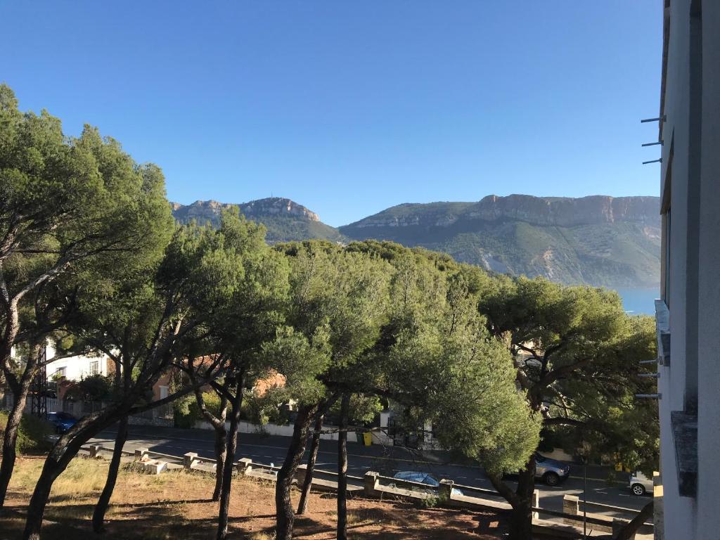 um grupo de árvores com montanhas ao fundo em Au son des Cigales em Cassis