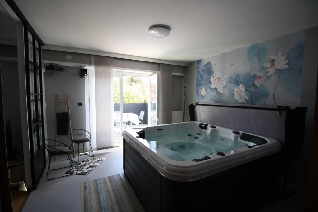 a bathroom with a large tub in the middle of a room at Villa Faby, Jacuzzy Sauna privatif in Saint-Maurice