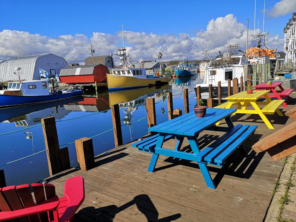 a picnic table on a dock with boats in the water at The Inn at Fisherman's cove in Halifax
