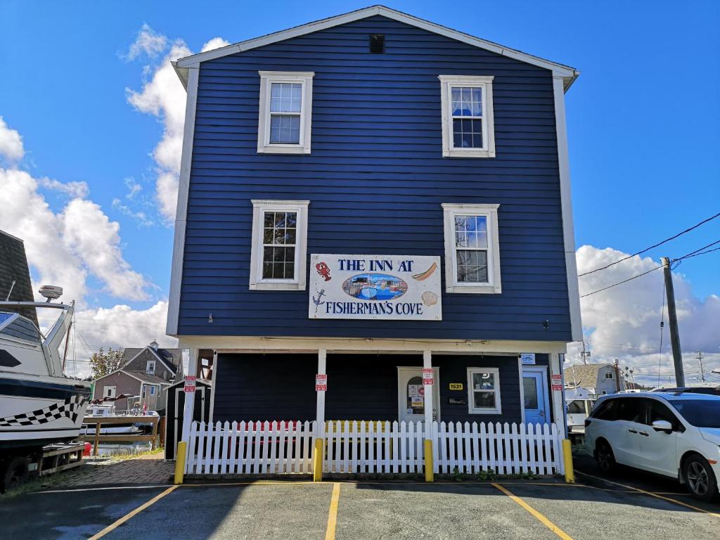 a blue house with a white fence in a parking lot at The Inn at Fisherman's cove in Halifax