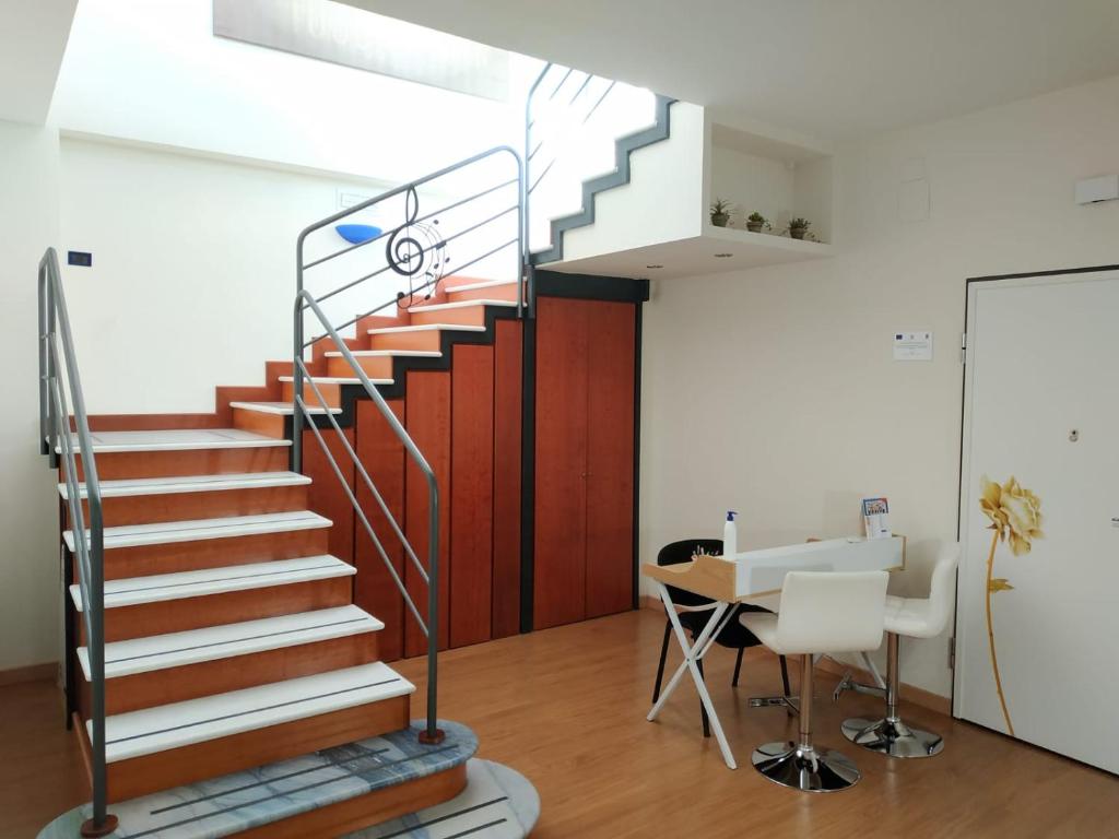 uma escada num escritório com uma mesa e cadeiras em Opera B&B em Foggia