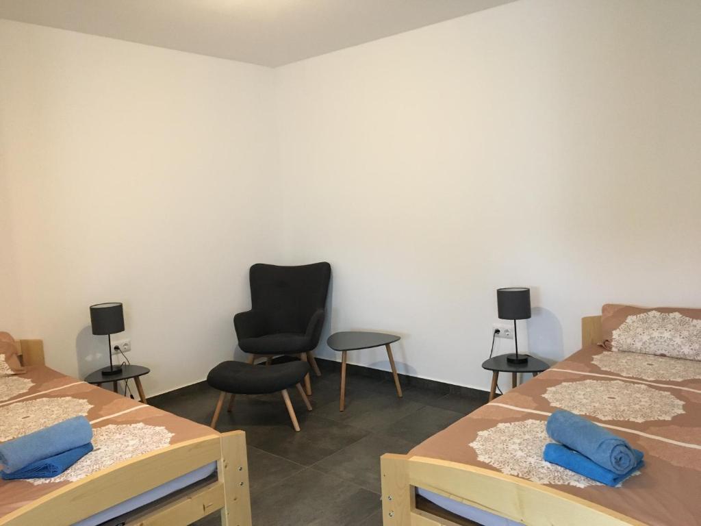 - une chambre avec deux lits, deux chaises et une chaise dans l'établissement Monteurwohnung 2, à Ingelheim-sur-le-Rhin