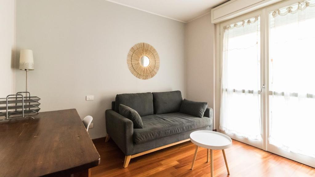 una sala de estar con un sofá y una mesa en Italianway - Cavour 75, en Cernusco sul Naviglio